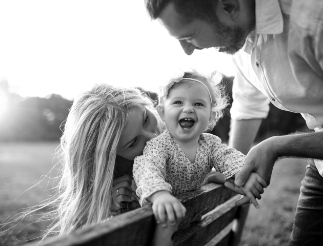 happy family in a field with a toddler