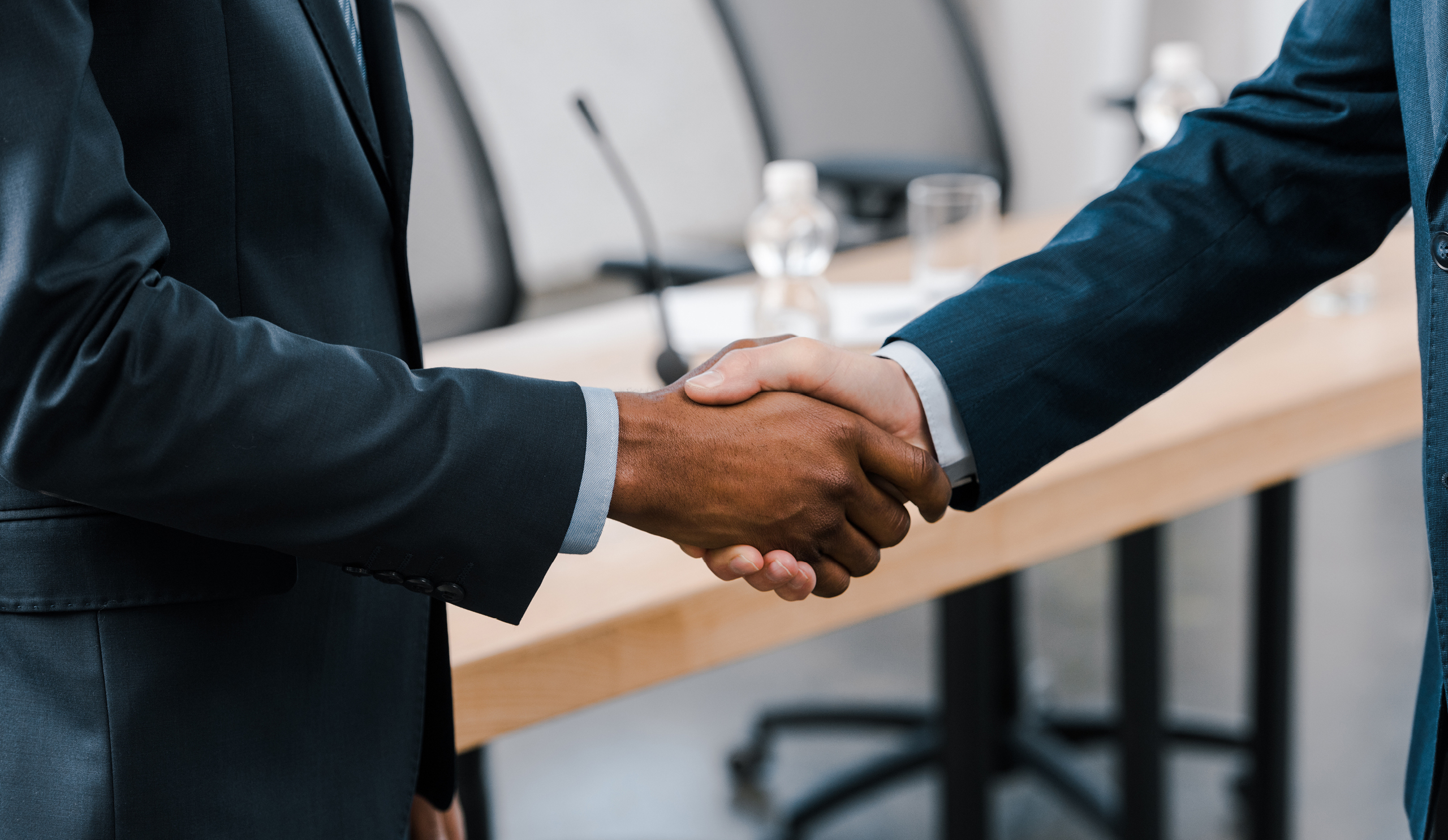 Two businessmen in suits shaking hands